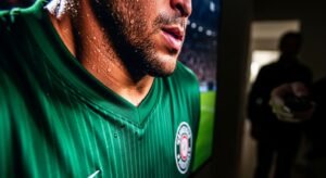 Macro fotografia de um ecrã de TV mostrando os detalhes extremos de um jogador de futebol numa transmissão IPTV 4K Portugal.